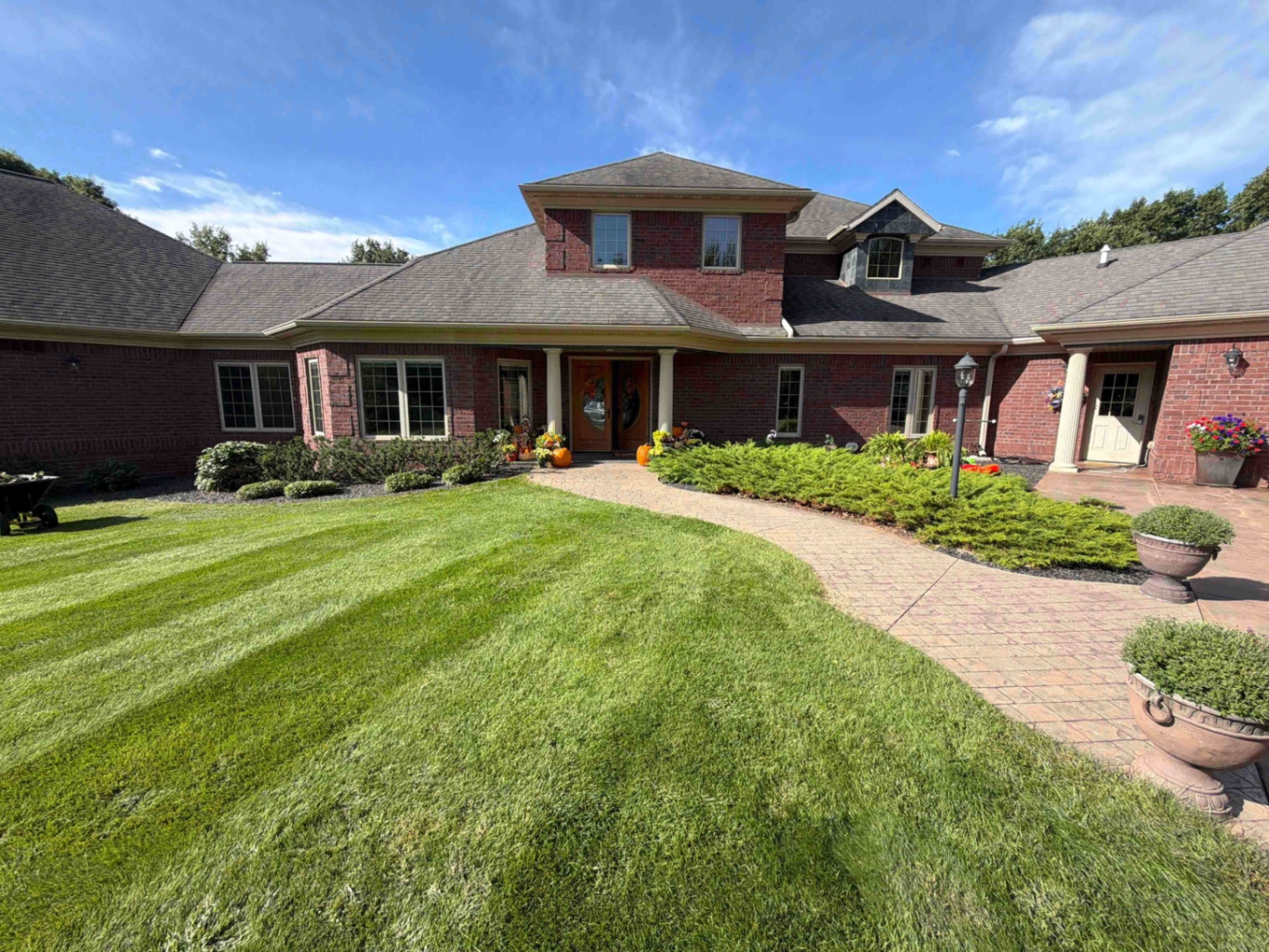 Finished No Plan LLC landscaping project with a maintained lawn, paver walkway and refreshed planting beds at a Central Wisconsin home
